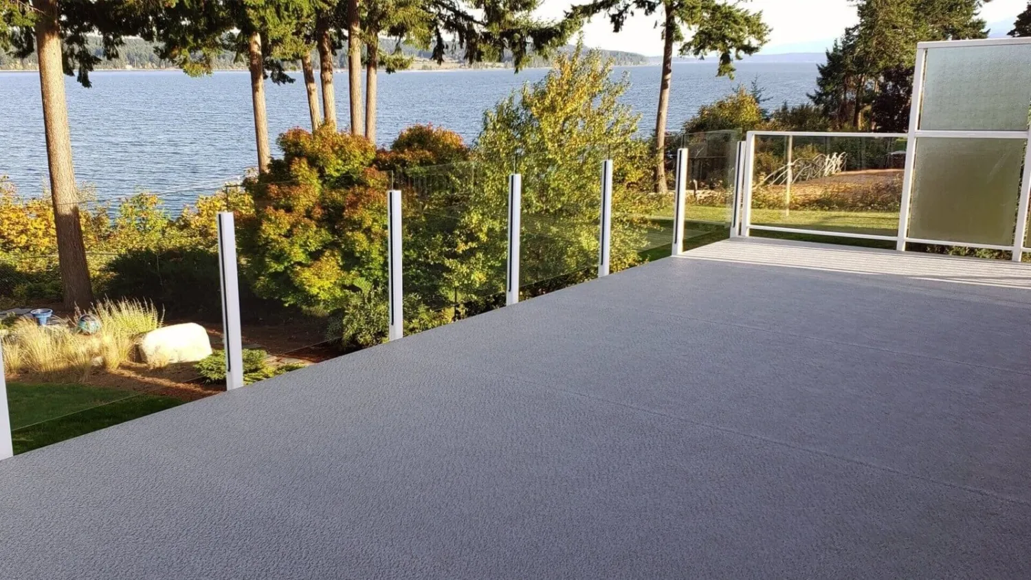 DeckRite membrane deck with glass railing beside water